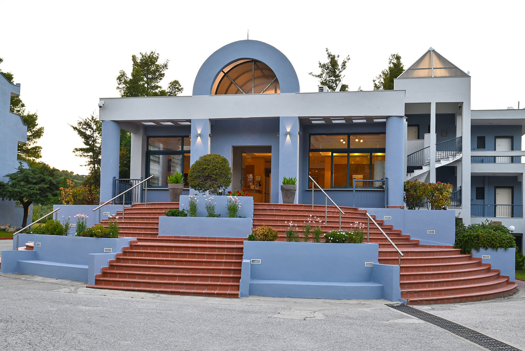 Atrium Hotel entrance steps with the lit lobby at dusk